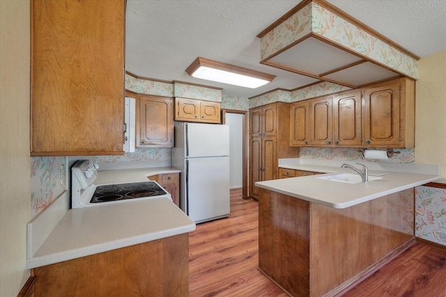 2912 Doncaster Dr, Charleston, SC 29414 - kitchen with white appliances, a textured ceiling, wallpapered walls, light wood finished floors, and a peninsula