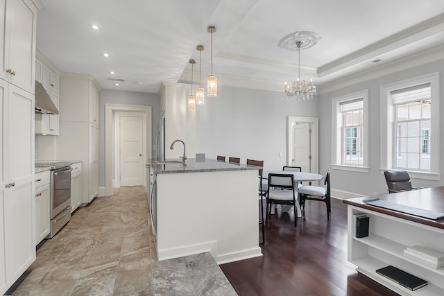 1 King Unit 702, Charleston, SC 29401 - kitchen with stainless steel appliances, under cabinet range hood, a chandelier, ornamental molding, and white cabinets