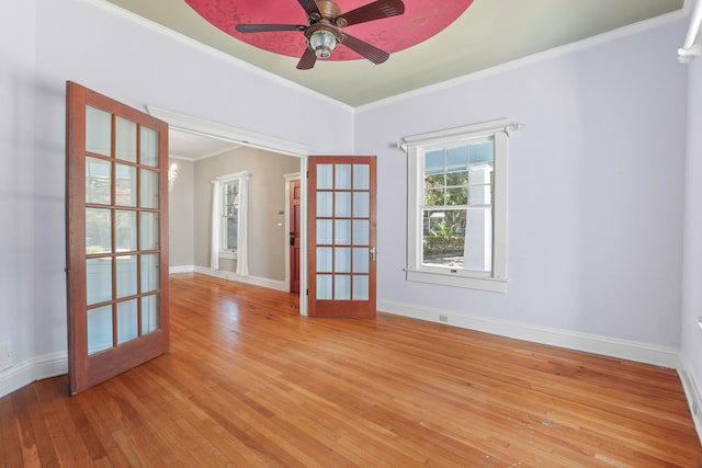 spare room with french doors, light hardwood / wood-style floors, crown molding, and ceiling fan