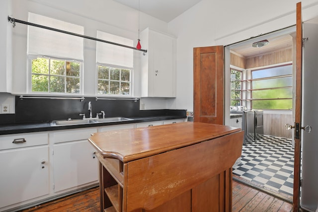 kitchen with white cabinetry, washer and dryer, sink, and a wealth of natural light