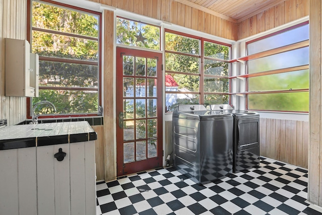 interior space with wood walls, washing machine and dryer, and a wealth of natural light