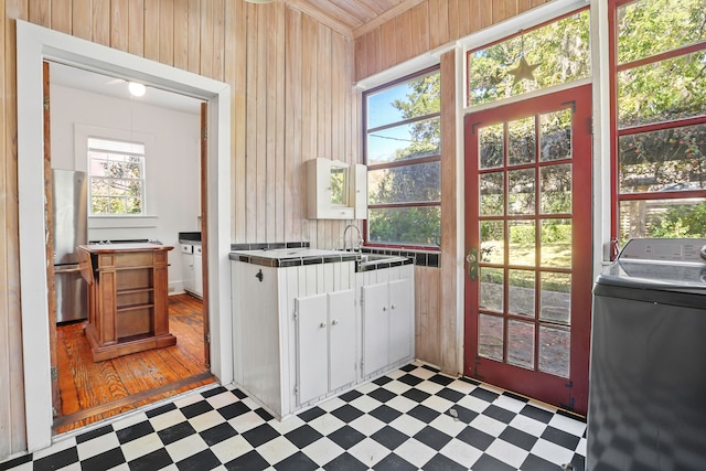 kitchen with tile countertops, washer / dryer, light hardwood / wood-style flooring, stainless steel fridge, and white cabinetry