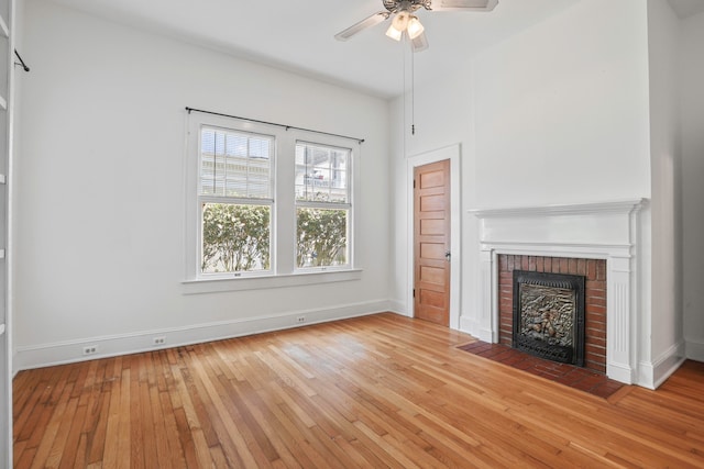 unfurnished living room featuring light hardwood / wood-style floors, a fireplace, and ceiling fan