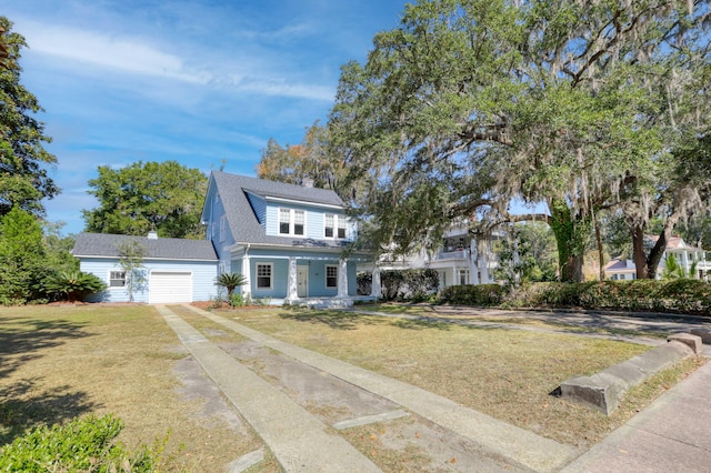 view of front facade with covered porch, a front yard, and a garage