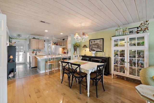 dining space with crown molding, light hardwood / wood-style floors, wood ceiling, and a notable chandelier