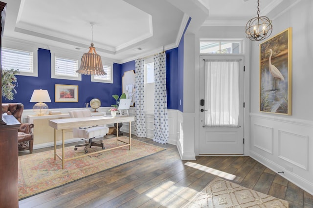 office featuring a tray ceiling, crown molding, a chandelier, and dark hardwood / wood-style floors