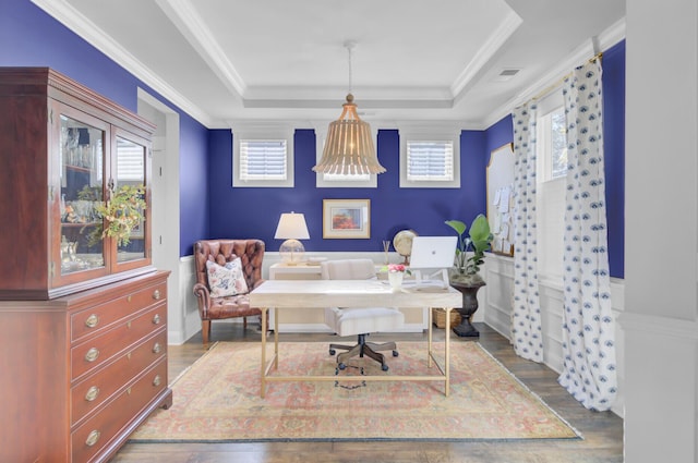 office space featuring hardwood / wood-style flooring, a raised ceiling, and ornamental molding