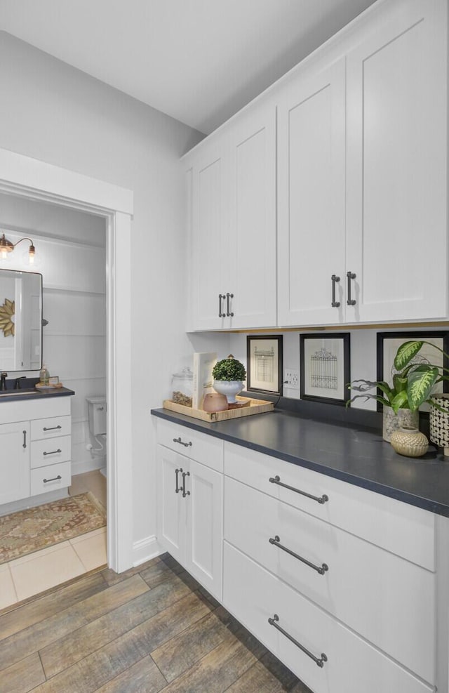 kitchen with dark hardwood / wood-style flooring and white cabinetry