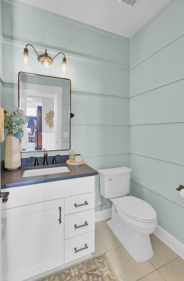 bathroom featuring toilet, vanity, and tile patterned floors