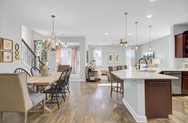 dining space featuring sink, dark hardwood / wood-style floors, and ceiling fan with notable chandelier