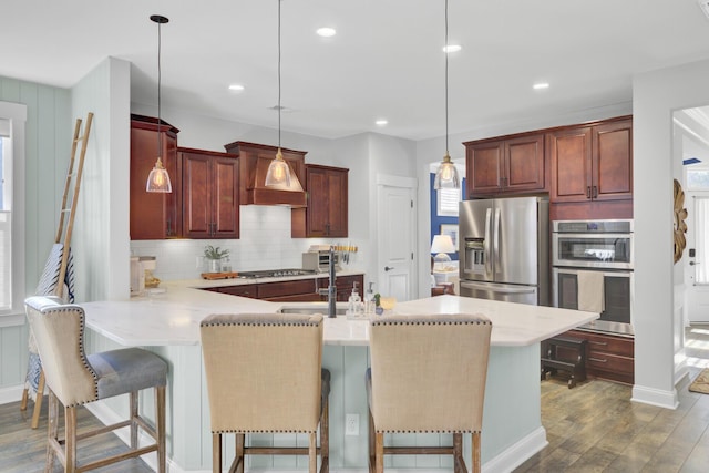 kitchen with premium range hood, hanging light fixtures, and appliances with stainless steel finishes