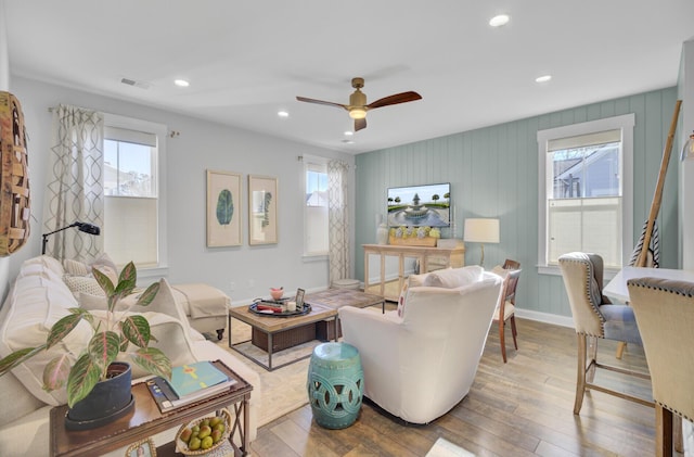 living room featuring wood-type flooring, ceiling fan, and a wealth of natural light