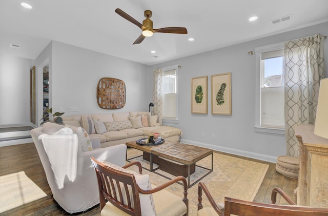 living room featuring ceiling fan and dark hardwood / wood-style floors