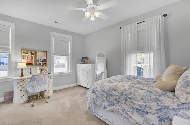 carpeted bedroom featuring ceiling fan and multiple windows