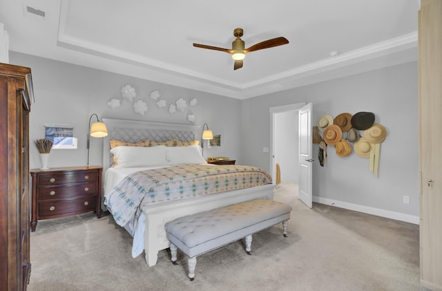 carpeted bedroom featuring ceiling fan and a tray ceiling