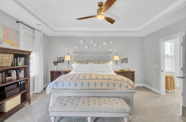 carpeted bedroom featuring ceiling fan and a tray ceiling