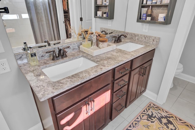 bathroom with toilet, tile patterned flooring, and vanity