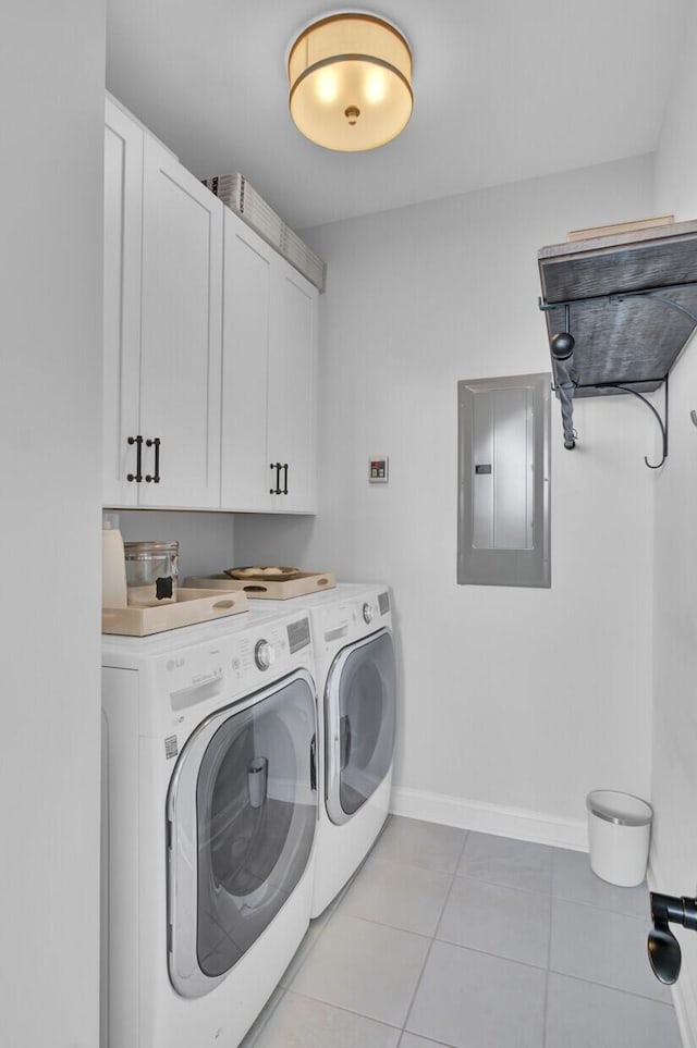 washroom featuring light tile patterned floors, washer and clothes dryer, electric panel, and cabinets