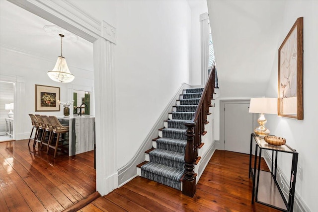 stairs with an inviting chandelier and wood-type flooring