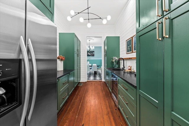 kitchen with a chandelier, stainless steel fridge, green cabinetry, dark wood-type flooring, and sink