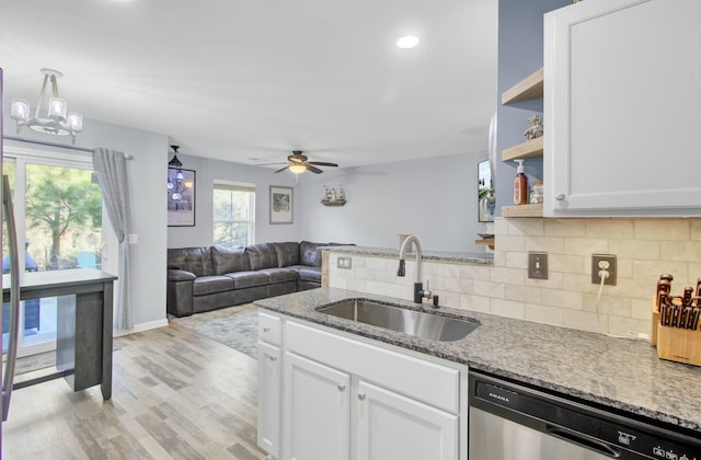 kitchen featuring sink, white cabinetry, light stone counters, stainless steel dishwasher, and ceiling fan