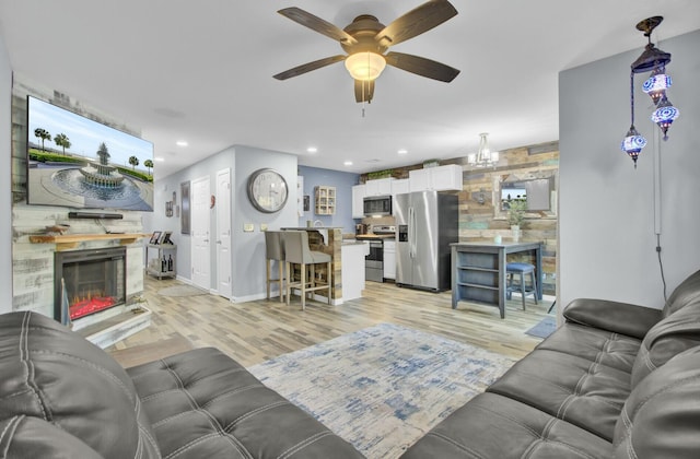 living room featuring ceiling fan and light hardwood / wood-style flooring