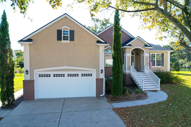 view of front of house featuring brick siding, driveway, and stucco siding