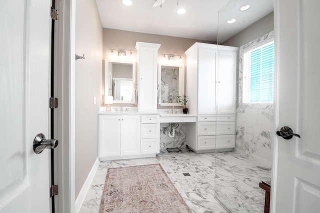 full bath with marble look tiles, recessed lighting, double vanity, and baseboards