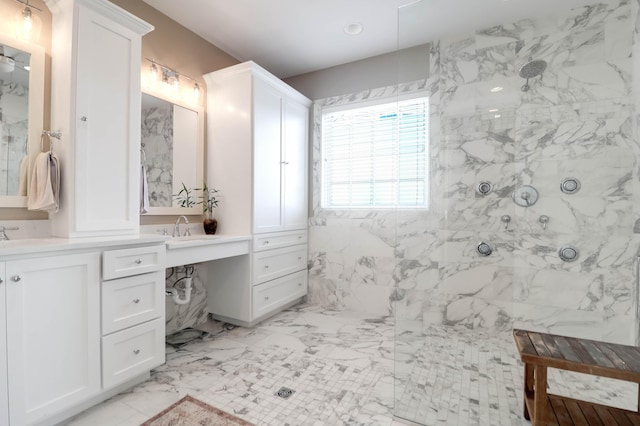 bathroom with a marble finish shower, marble finish flooring, and double vanity