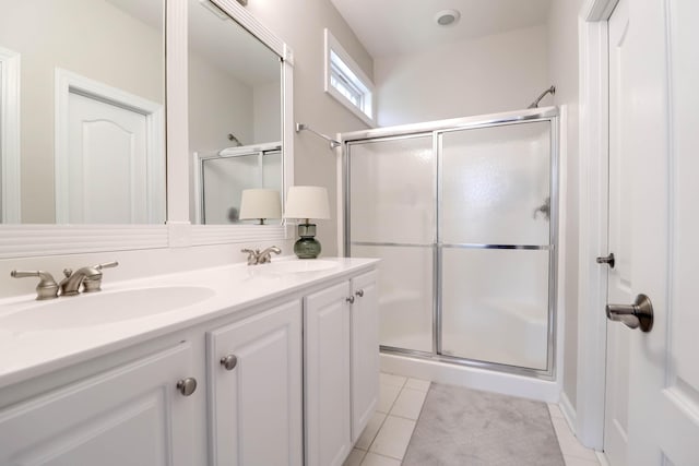 full bathroom featuring a stall shower, tile patterned flooring, and double vanity