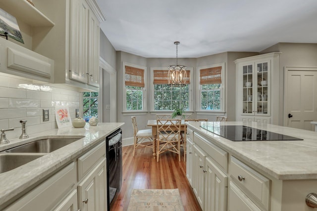 kitchen featuring light hardwood / wood-style floors, decorative light fixtures, a chandelier, and plenty of natural light