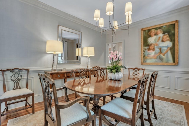 dining room featuring crown molding, light hardwood / wood-style flooring, and a notable chandelier