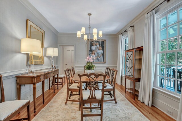 kitchen featuring decorative light fixtures, light wood-type flooring, black electric cooktop, a notable chandelier, and double oven