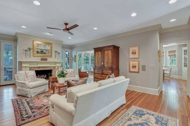 living room with a healthy amount of sunlight, light wood-type flooring, and ceiling fan