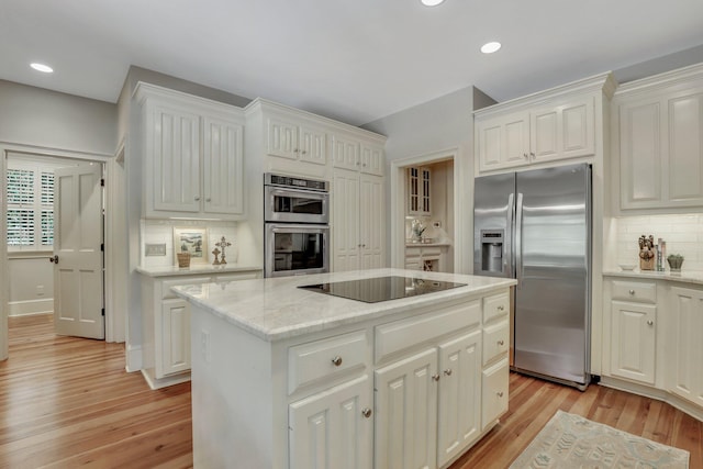 kitchen with a center island, appliances with stainless steel finishes, and light hardwood / wood-style floors