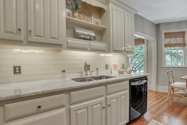 kitchen with white cabinetry, tasteful backsplash, light wood-type flooring, sink, and dishwasher