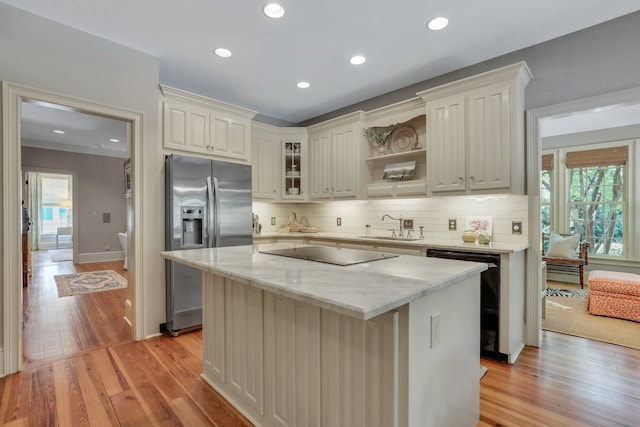 kitchen with a kitchen island, decorative backsplash, light wood-type flooring, and black appliances