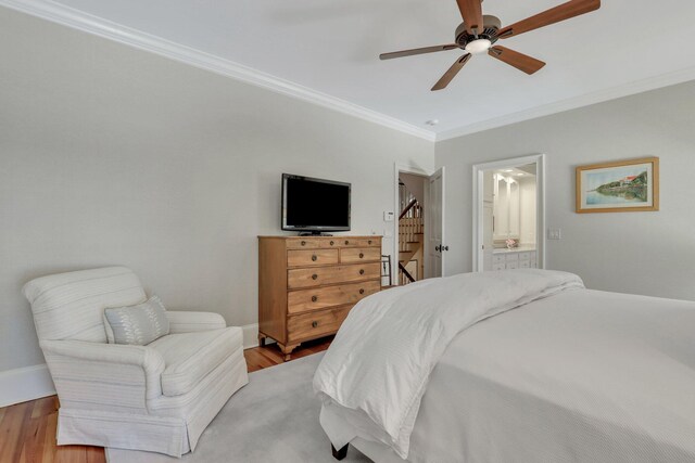 bedroom with ornamental molding, hardwood / wood-style floors, ensuite bath, and ceiling fan