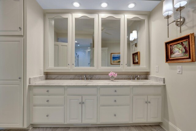 kitchen with appliances with stainless steel finishes, tasteful backsplash, light stone counters, light wood-type flooring, and white cabinetry