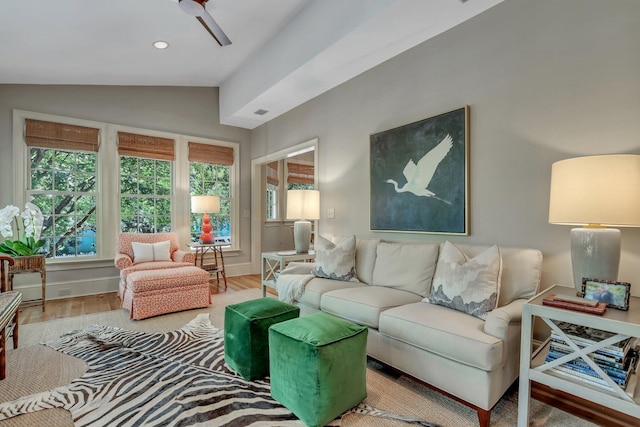 living room featuring light hardwood / wood-style floors, ceiling fan, and vaulted ceiling