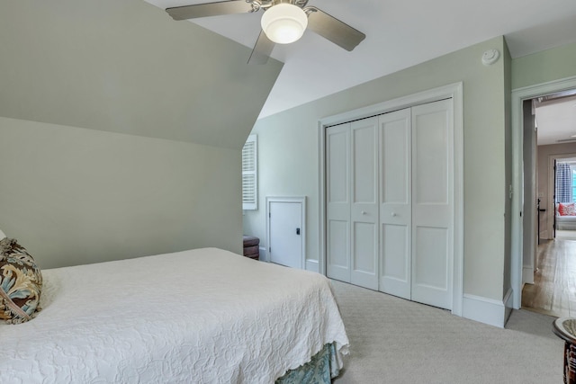 carpeted bedroom featuring vaulted ceiling, a closet, and ceiling fan