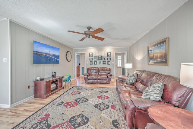 living room with a textured ceiling, light wood finished floors, and a ceiling fan