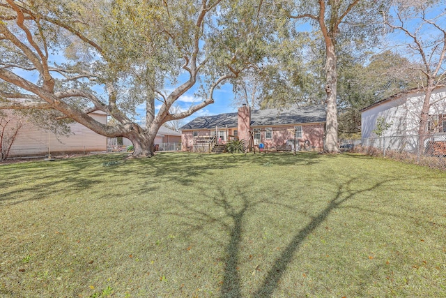 view of yard featuring fence and a deck