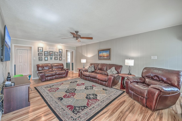 living area with light wood-style floors, a textured ceiling, and a ceiling fan