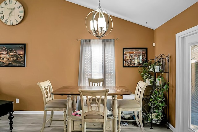 dining space featuring light hardwood / wood-style flooring, a chandelier, and vaulted ceiling