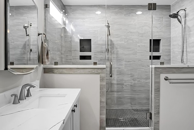 bathroom featuring vanity and a shower with door