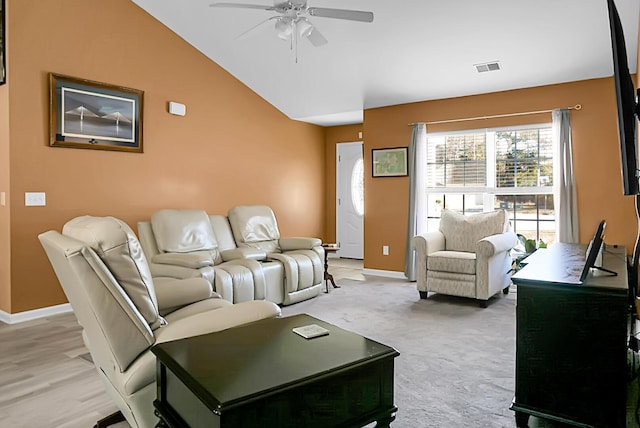 carpeted living room with ceiling fan and vaulted ceiling