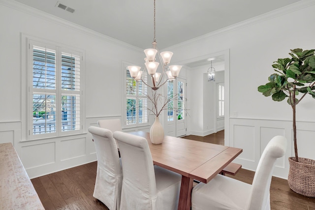 dining space with dark hardwood / wood-style flooring, a chandelier, and crown molding