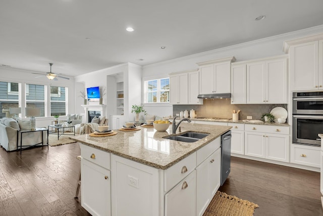 kitchen featuring a center island with sink, stainless steel appliances, ceiling fan, sink, and white cabinetry