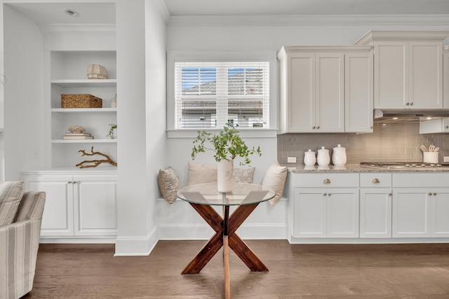 interior space featuring dark hardwood / wood-style flooring, ornamental molding, and breakfast area